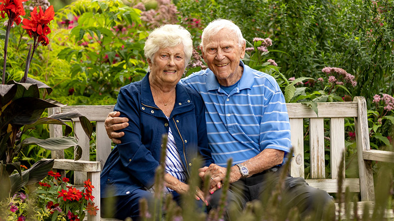 Outdoor photo of a senior couple on a garden bench